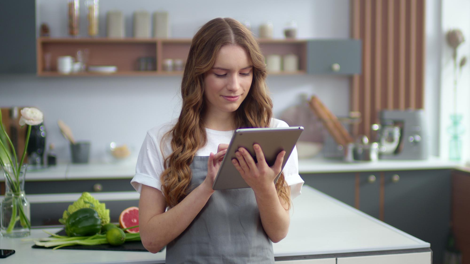 Student cooking at home using a tablet